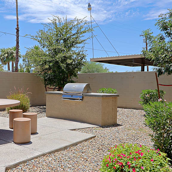 A patio with a table, chairs and plants.