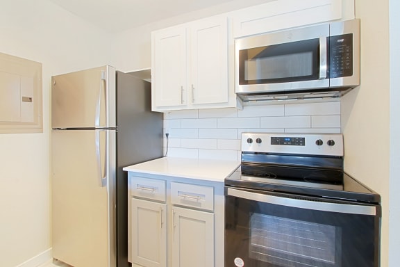 a kitchen with white cabinets and stainless steel appliances
