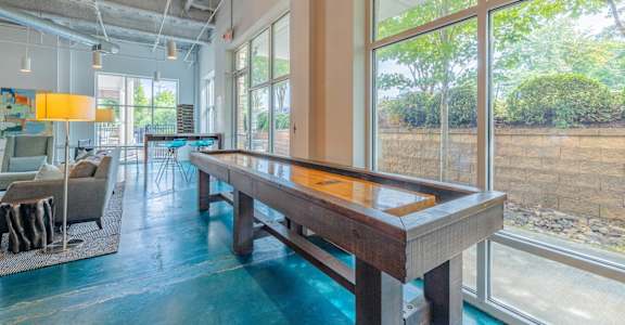 A pool table in a room with a view of a rocky landscape outside the window.