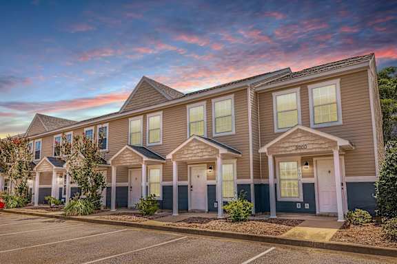 A row of townhouses with a parking lot in front. at Sterlington Apartments, Grovetown, GA, 30813