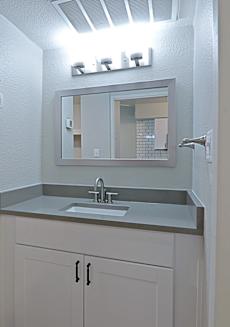 A bathroom with a sink and mirror.