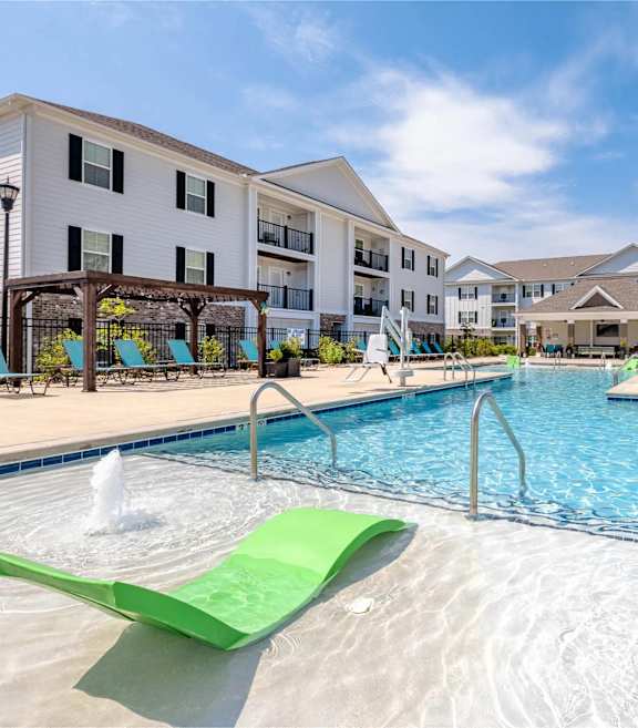 a swimming pool with lounge chairs and a building with a pool