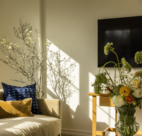 a living room with a couch and a vase of flowers