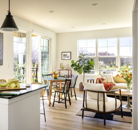 a kitchen with a counter top and a dining room with a table and chairs