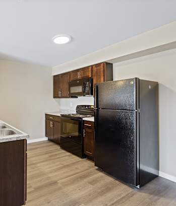 a kitchen with black appliances and a stainless steel refrigerator