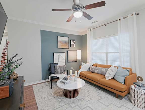 a living room with a couch and a ceiling fan