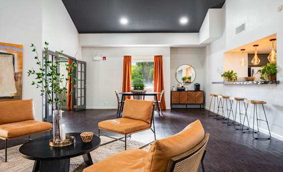 A living room with orange chairs and a black table.