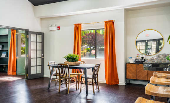 A dining room with a table and chairs.