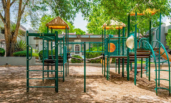 A playground with a green slide and a yellow top.