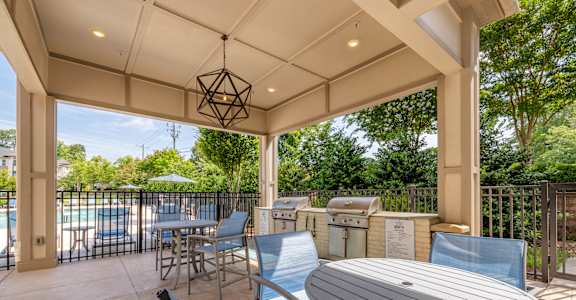 A patio with a table and chairs under a roof.