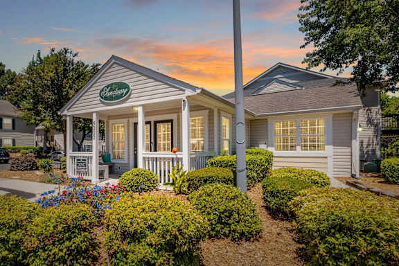 A small house with a porch and a sign that says  at Sanctuary Apartments & Townhomes, Augusta