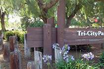 A brown sign that says Tri-City Park.