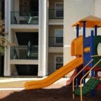 A playground with a yellow slide and a green and blue structure. at Oak Glen Apartments, Orlando, 32808