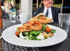 a plate of food on a table with a man