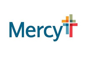 The image shows a logo with the word "Mercy" and a graphic of a cross with multiple colors.