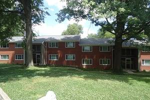 A red brick building with a tree in front.