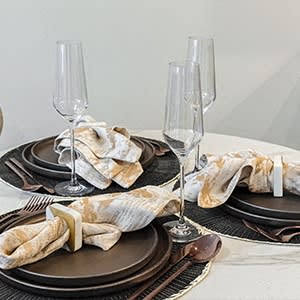 a table set with plates and utensils and a table cloth with wine glasses at The Botanic, Carteret, New Jersey