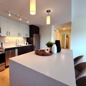 A modern kitchen with a white island and stainless steel appliances.