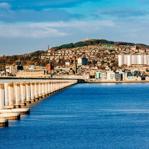 A long row of concrete pillars are in the water.