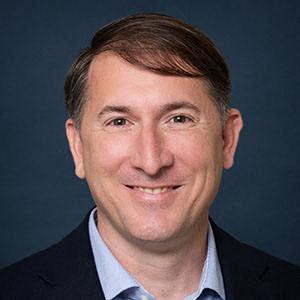 a man wearing a suit and tie and a blue shirt