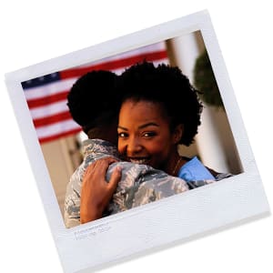 a photo of a woman in a military uniform hugging a soldier in front of an american