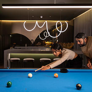 a man and woman playing a game of pool on a blue pool table