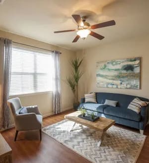 a living room filled with furniture and a ceiling fan