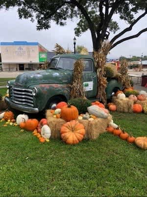 an old truck is decorated with pumpkins and hay bales