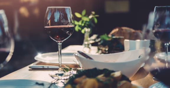 a table with a glass of wine and a bowl of food