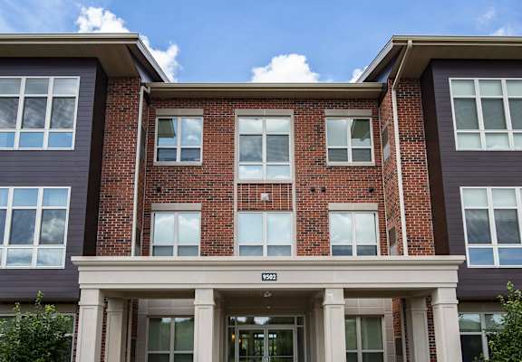 a red brick apartment building with white columns