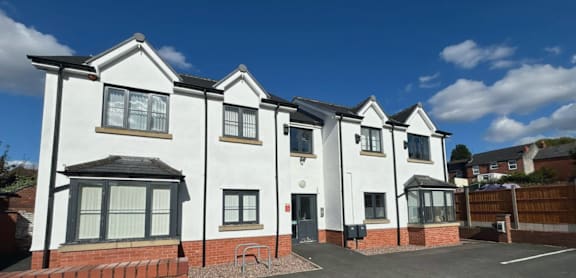 A row of white houses with black roofs and windows.