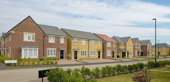 A row of houses with a black sign in front.