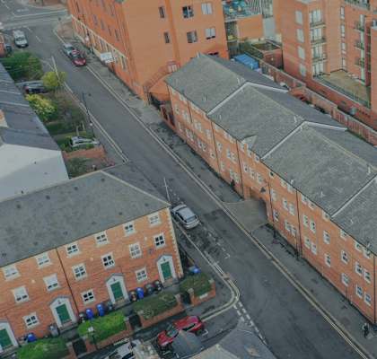 A street view of a residential area with red brick buildings.