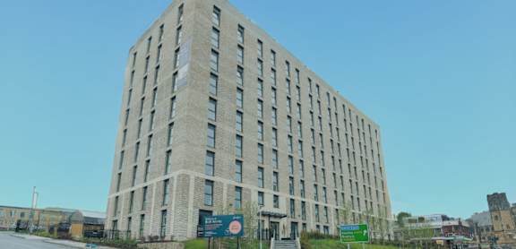 A tall building with many windows is the main focus of the image.