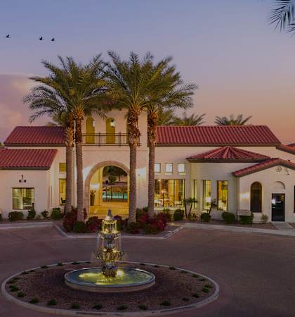 a fountain in the center of a courtyard in front of the clubhouse
