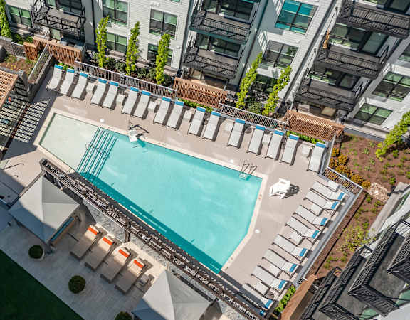 Resort-style swimming pool with sun shelf and lounge chairs - Rockwell at Crown