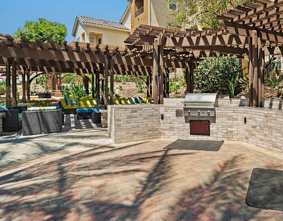 a backyard with BBQs and pergolas
