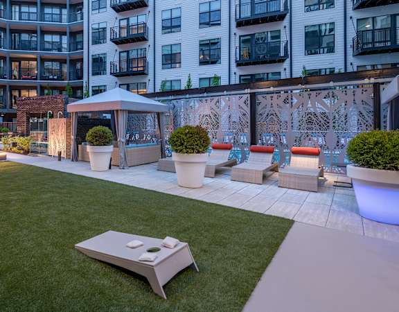 Pool-side outside lounge area with fire pit and games - Rockwell at Crown