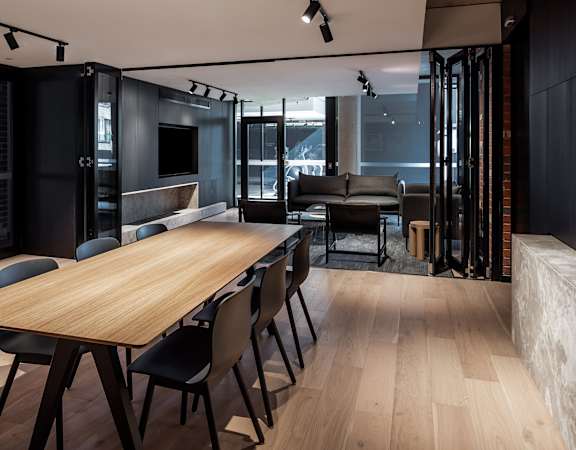a dining room and living room with a wooden table and chairs