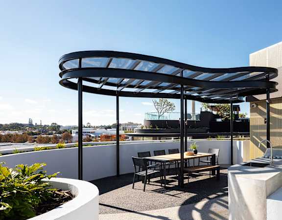 a roof terrace with a table and chairs and a black canopy