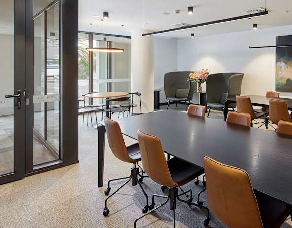 a conference room with a table and chairs and a painting on the wall