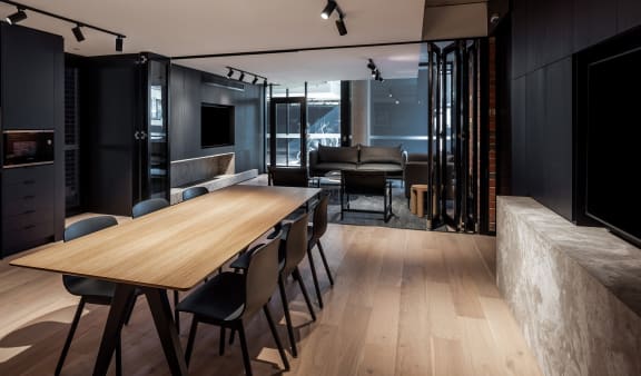 a dining room and living room with a wooden table and chairs