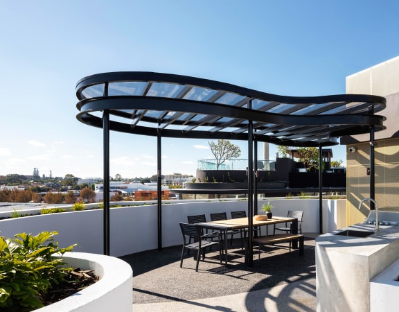 a roof terrace with a table and chairs and a black canopy