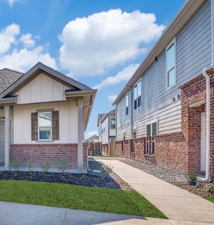 A row of houses with a well-maintained lawn in front.