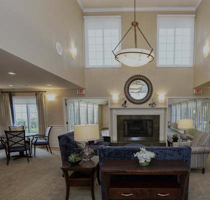 a large living room with a fireplace and a table and chairs