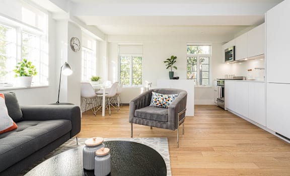 A modern living room with a grey sofa and a grey armchair.