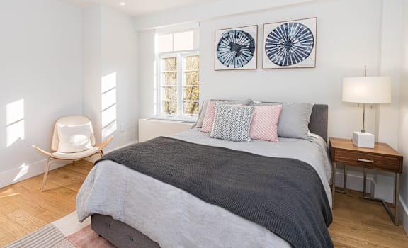 A bedroom with a large bed and two wall art pieces.