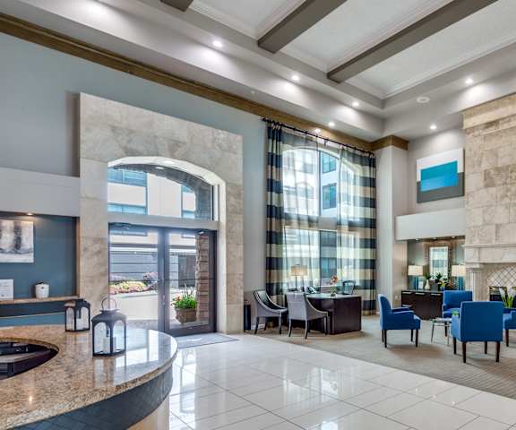 the lobby of a hotel with tables and chairs and a fireplace