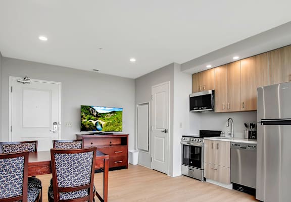 A modern kitchen with a TV mounted above the counter.