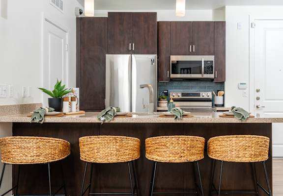 A kitchen with a bar stool and a counter.